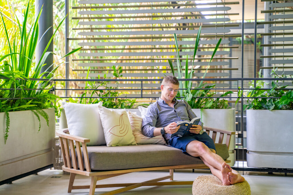 Max sitting on a couch reading a book on a retreat